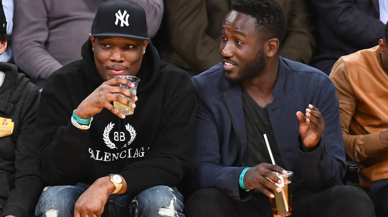Michael Che drinking beverage at game