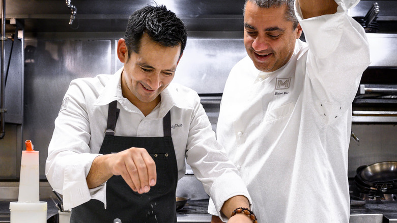 Michael Mina and chef prepare food in kitchen