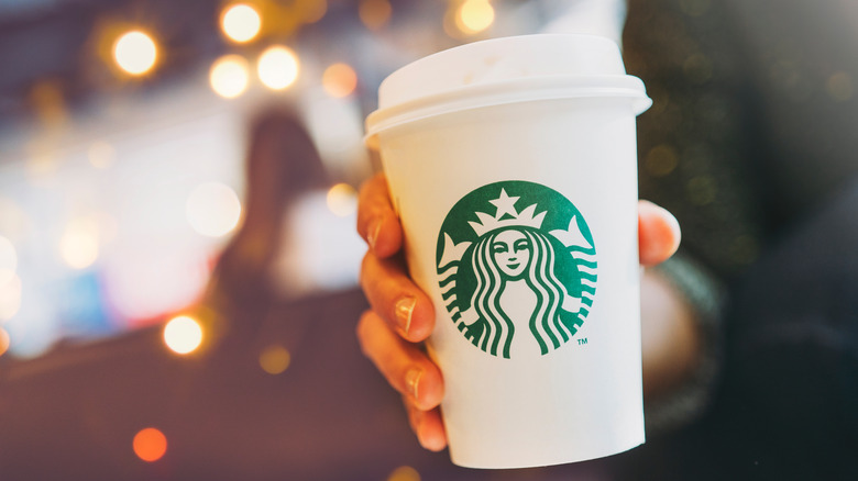 A Starbucks hot coffee being handed to someone