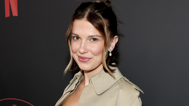 Millie Bobby Brown smiling for cameras at publicity event.