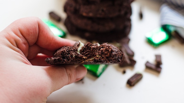 A hand holding a chocolate cookie