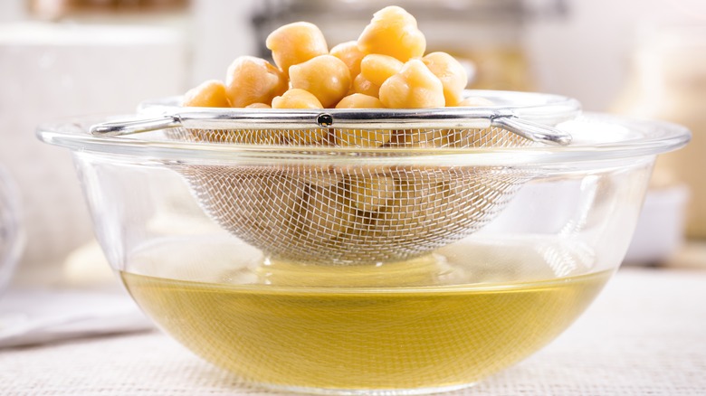 Draining aquafaba into a bowl