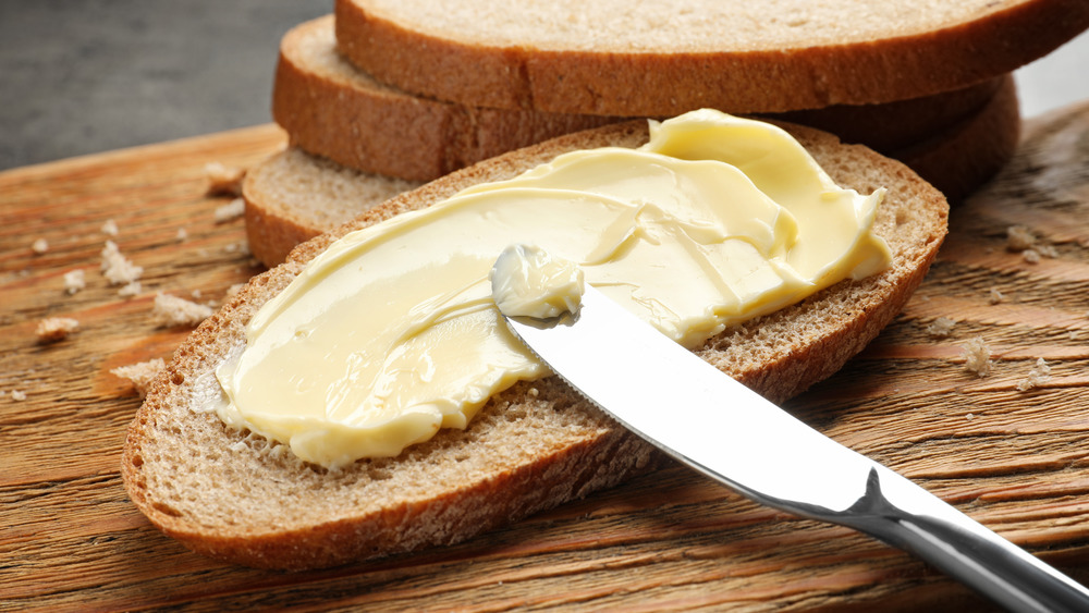 Knife spreading butter on toast
