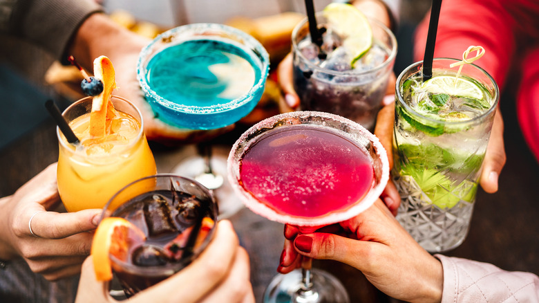 hands clinking colorful drinks