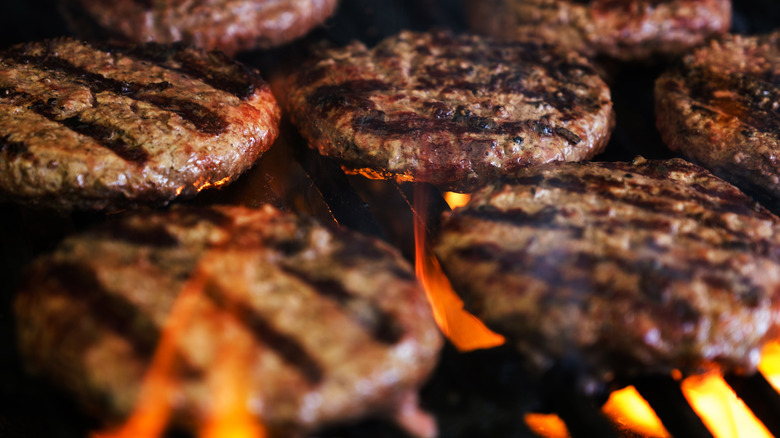 close-up of burgers on flaming grill