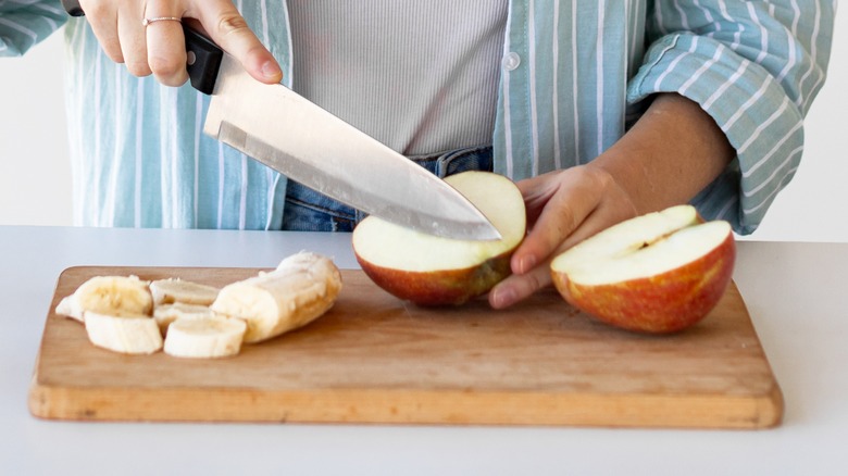 Woman cutting fresh apples