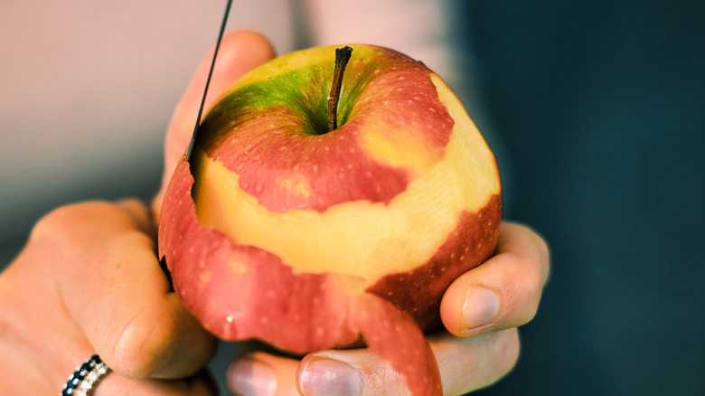 Woman peeling an apple