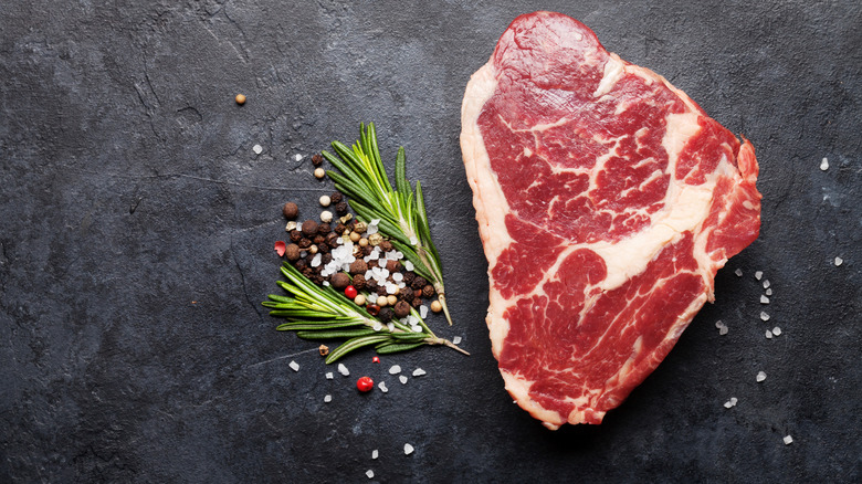 raw steak next to spices and herbs