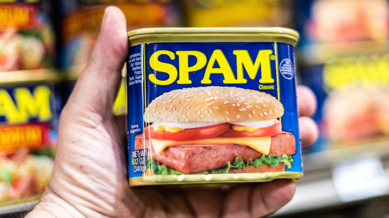 hand holding spam can in grocery store