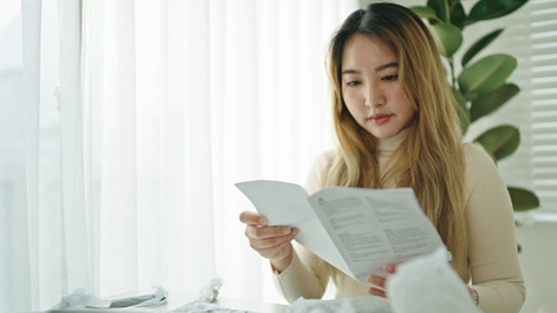 Woman reading instruction manual in bright room