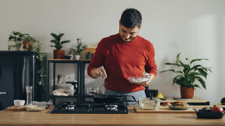 man sprinkling spices 