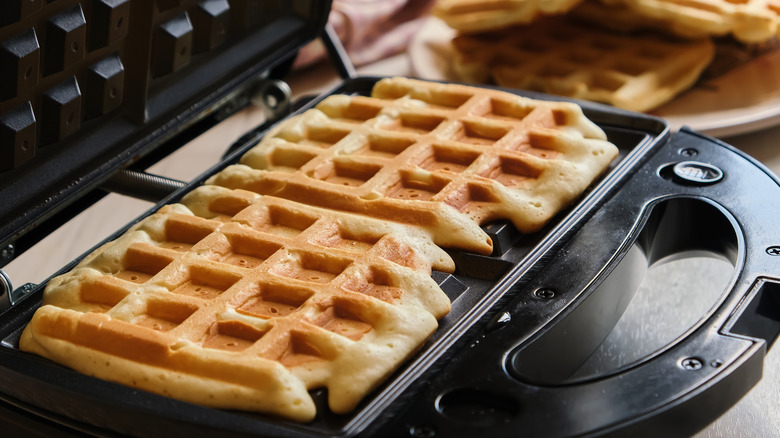 Waffles cooking on a waffle iron