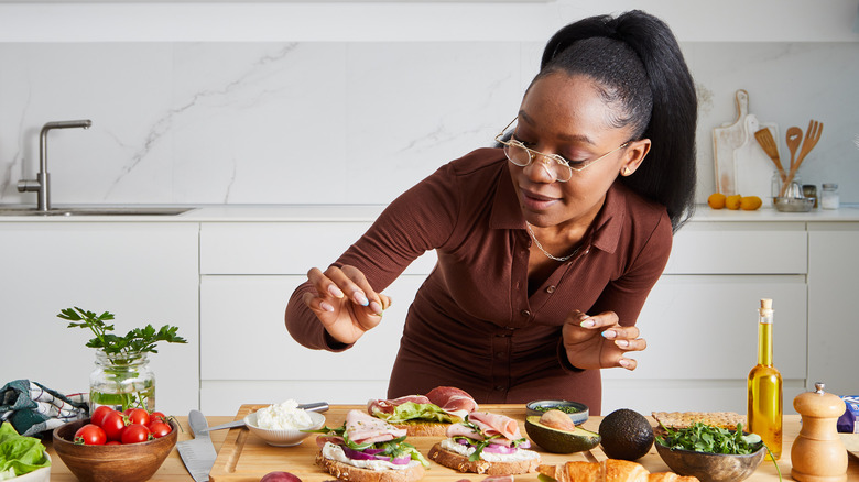 Woman seasoning sandwiches