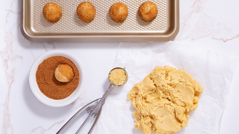 Raw snickerdoodle dough, some balls rolled in cinnamon sugar