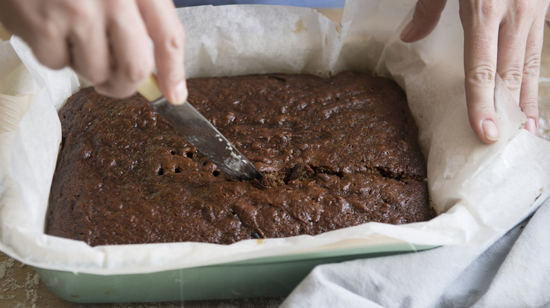 Person slicing brownies in the pan