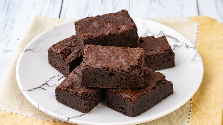 Brownies on a white plate with a yellow napkin underneath