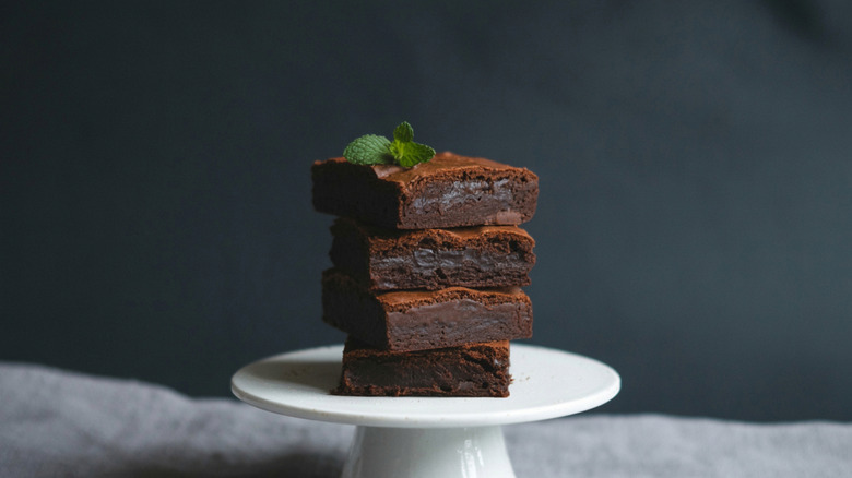 Fudgy brownies on a white cake platter