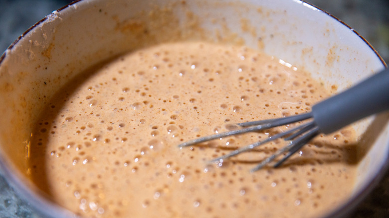 Bowl of beer batter with whisk inside