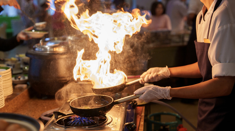 Chef flambéing on stove