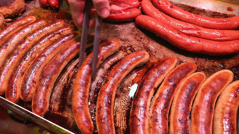 Person grilling brats on a tray