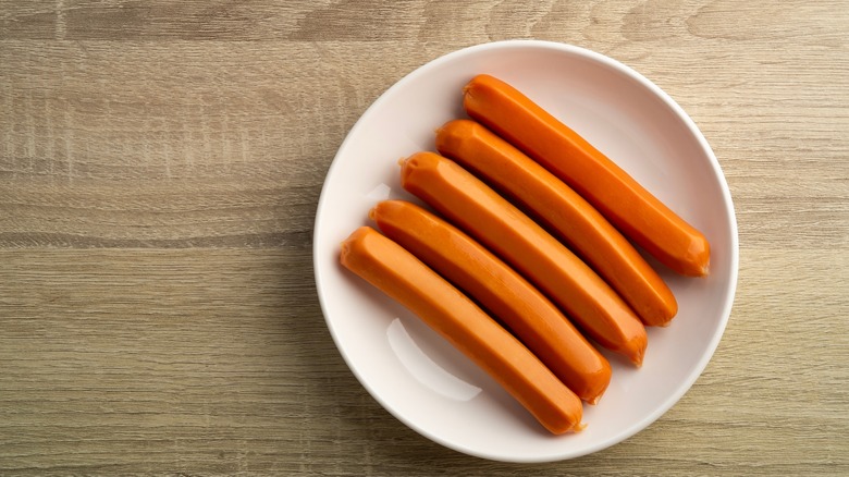 Plate of uncooked hot dogs