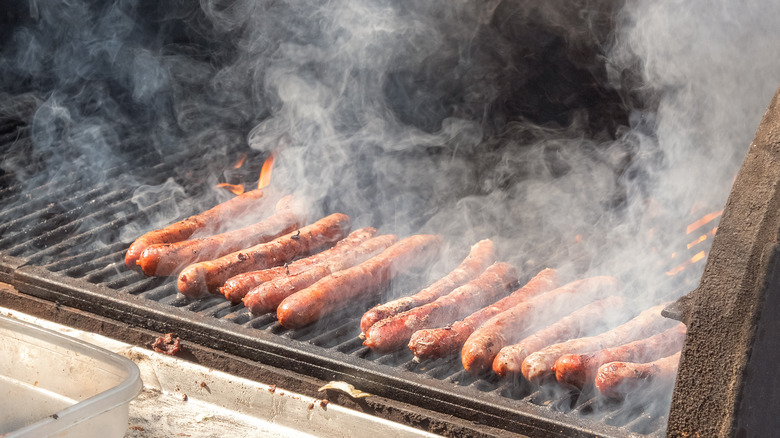 Steaming hot dogs on grill