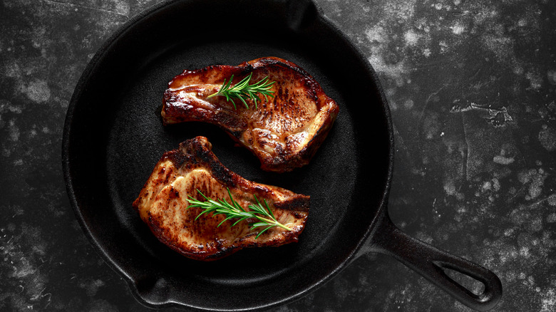 grilled pork chops in cast iron skillet with rosemary