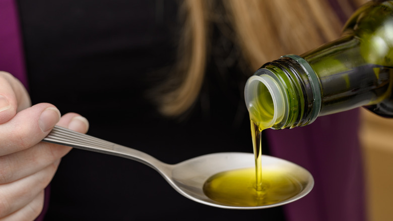Pouring olive oil into a tablespoon