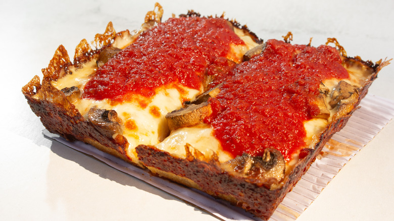 Detroit pizza covered in tomato sauce