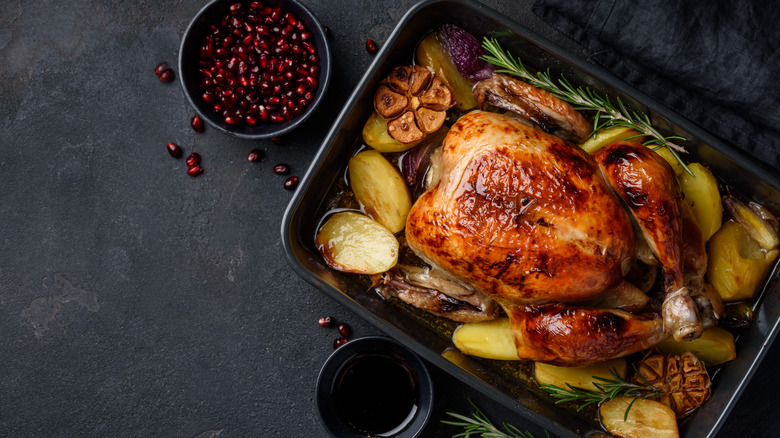 Roasted turkey on table next to cranberry seeds