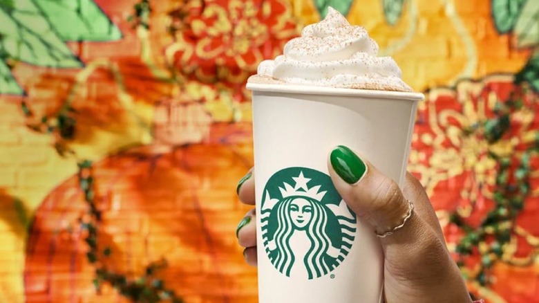 Woman holding Starbucks pumpkin spice latte