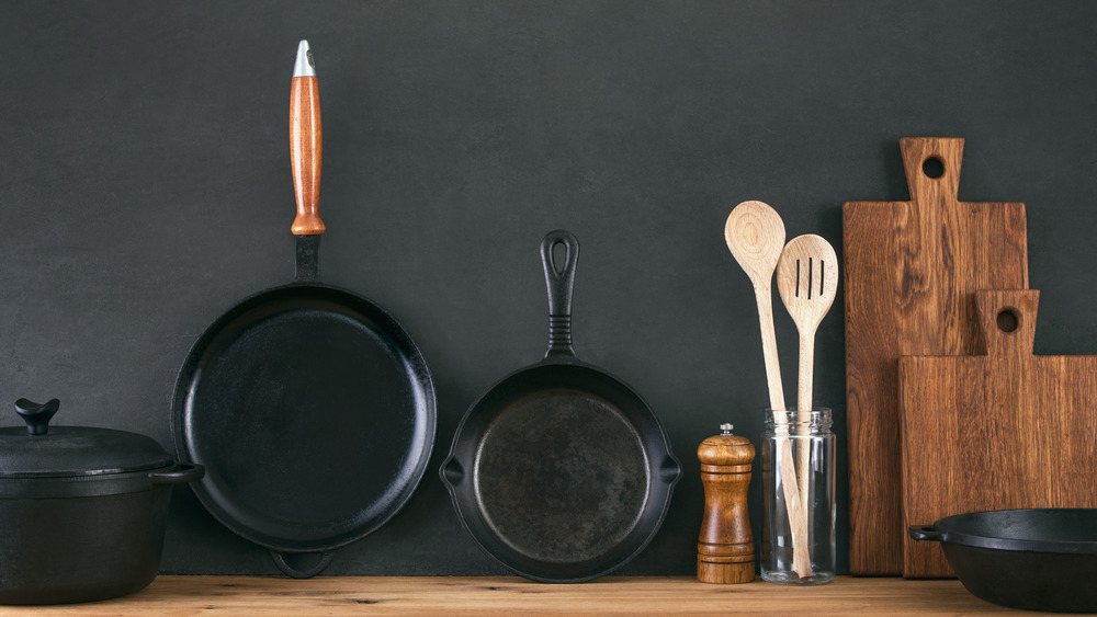 Cast iron skillets alongside a Dutch oven