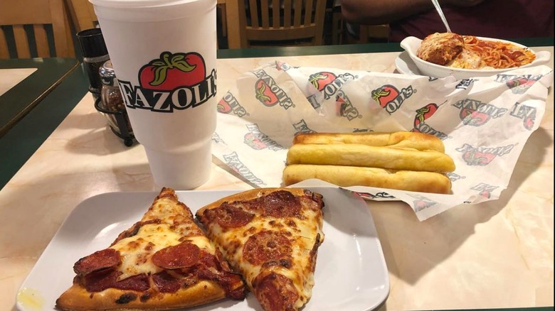 Pizza, pasta, and breadsticks with a drink from Fazolis