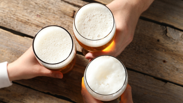 Hands with beer glasses at a table