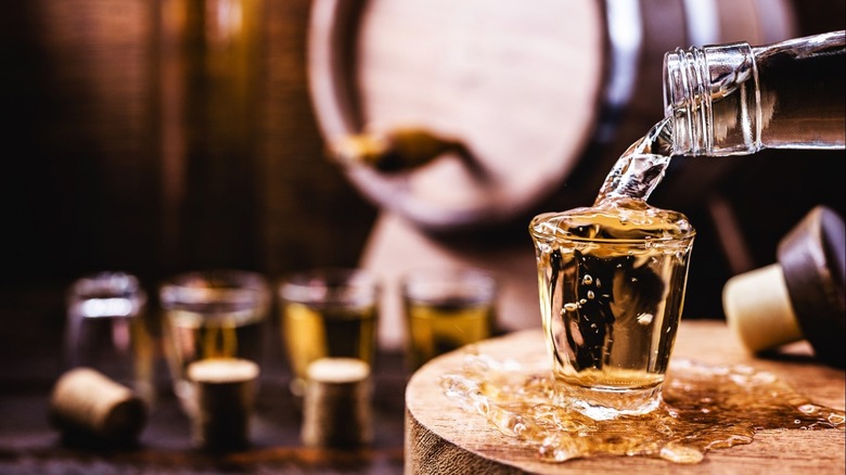 rum being poured from a bottle into a shot glass