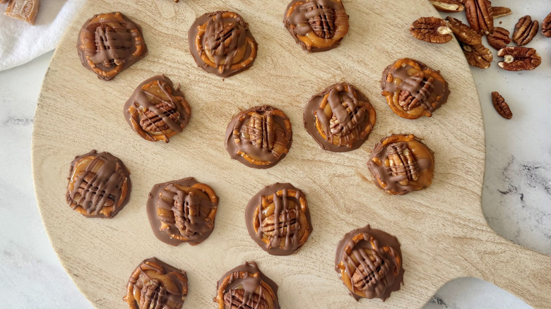 Chocolate pretzel turtles on wooden board