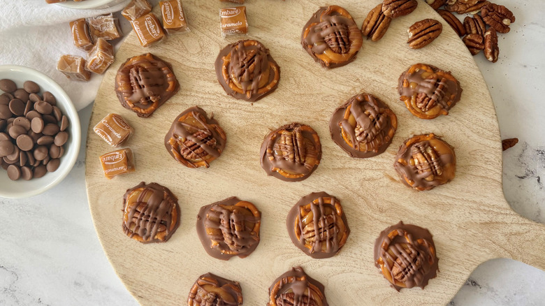 Chocolate pretzel turtles on wooden board