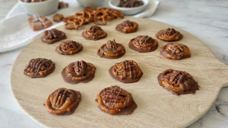 Chocolate pretzel turtles on wooden board
