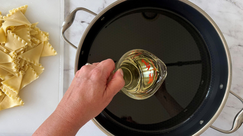 Hand pouring oil into pot