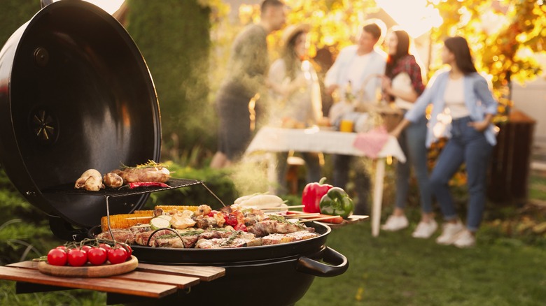 friends near an outdoor grill cooking food 