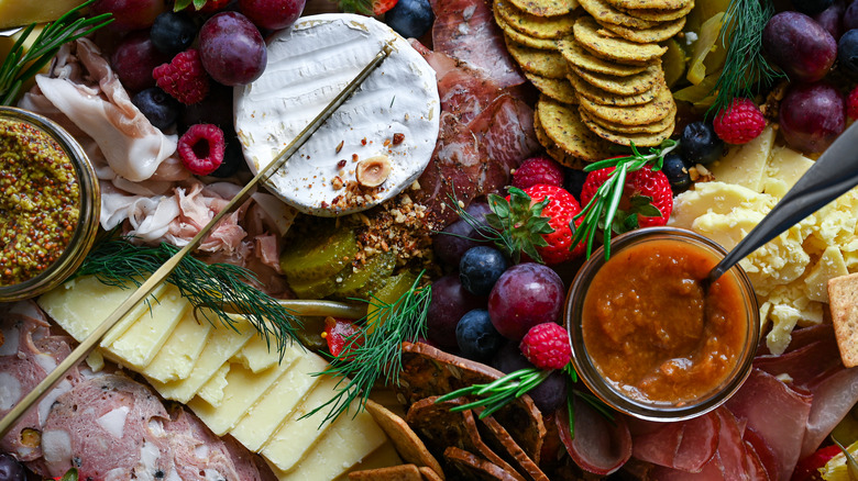 Piles of meat, cheese, and fruits