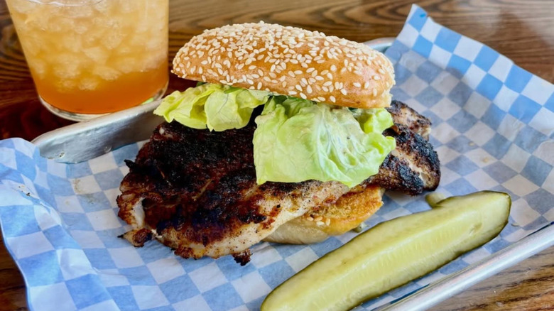 Fishmonger's blackened grouper sandwich with pickle and drink