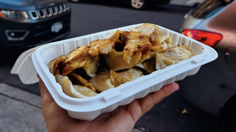 A pile of dumplings served in a plastic to-go container