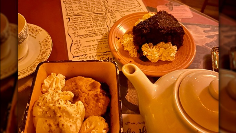 Cafe table with desserts, tea pot, and tea cup