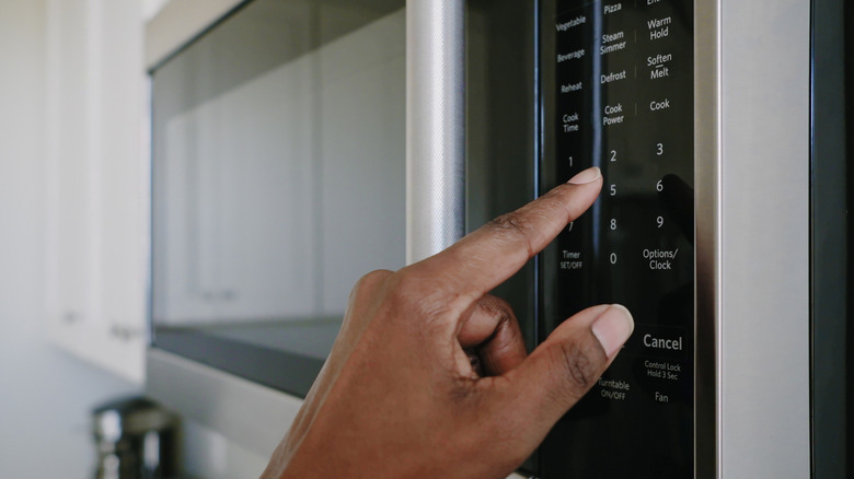 Person using microwave oven