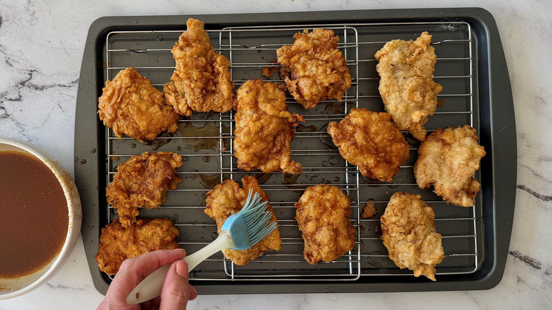 Brushing seasoned oil onto fried chicken