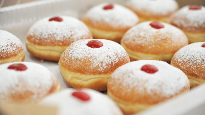 Box of jelly-filled donuts with powdered sugar