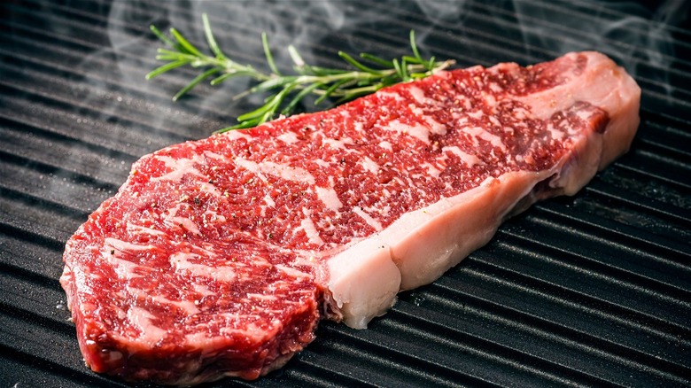 Raw steak on grill