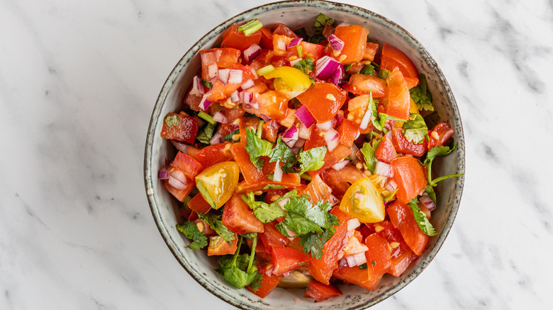 Top view of chunky tomato salsa in bowl