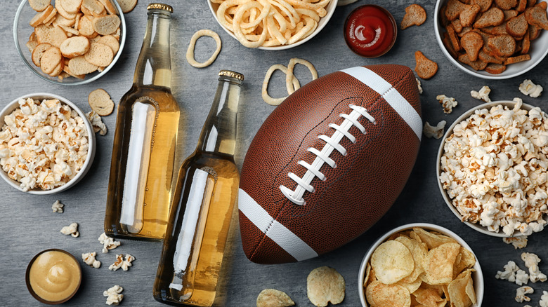 A football next to beer bottles and snacks